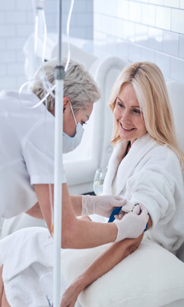 nurse administering IV therapy to woman